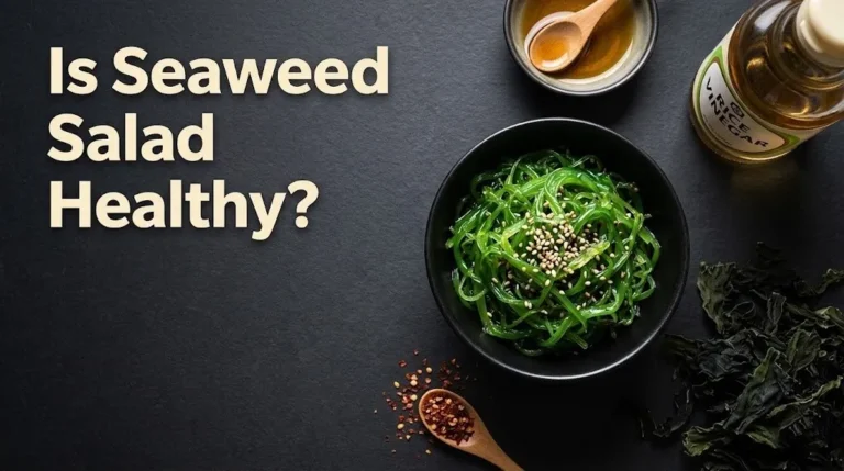 Overhead flat-lay of vibrant green seaweed salad in a black bowl with sesame oil and dried wakame, with the headline Is Seaweed Salad Healthy in cream type.